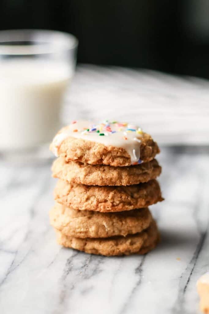 a stack of iced oatmeal cookies, milk in background