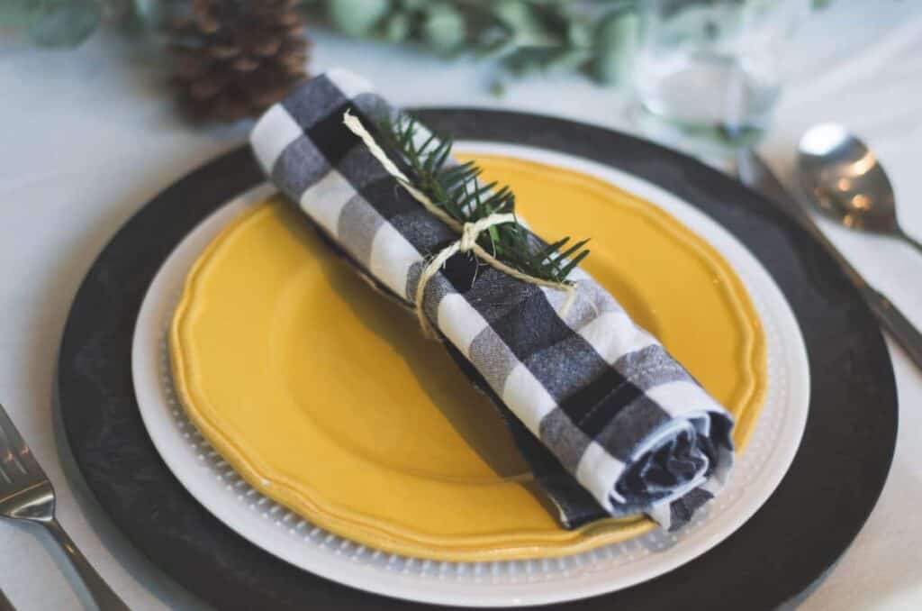 Photo by Libby Penner on Unsplash. Black and yellow holiday tablescape.