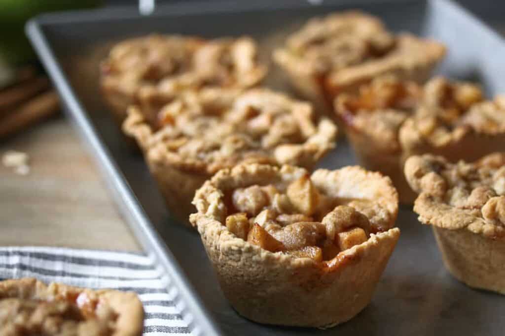 apple crisp cups on a silver tray, white and gray striped towel