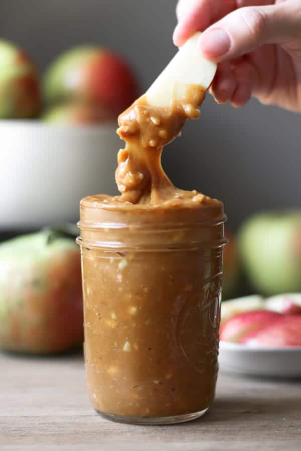 Carmel Apple Dip dripping from a sliced apple.