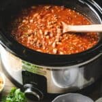 Chipotle Chicken Chili in a crock pot with wooden spoon