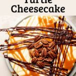 Gluten-free turtle cheesecake topped with caramel, chocolate drizzle, and pecans on a light plate.