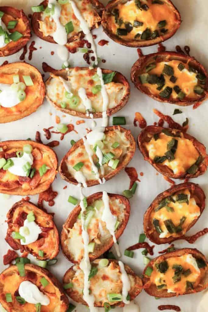 a tray of loaded potato skins with cheese, sour cream, and ranch drizzle