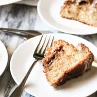 a slice of sour cream coffee cake on a white plate