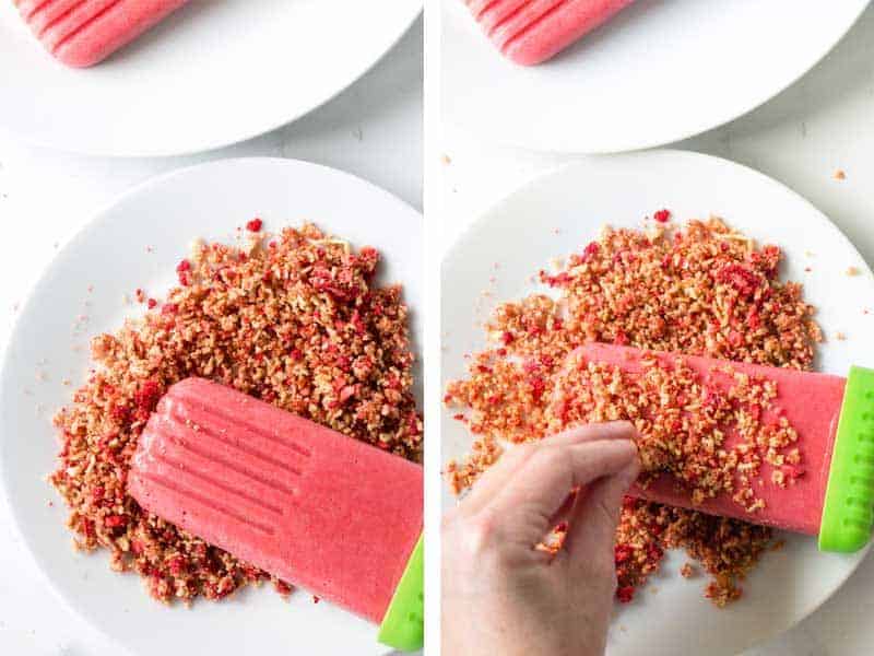 Dipping the popsicles in the strawberry and cereal crumble topping.