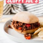Sloppy Joe sandwich in front of blue pot and striped towel.