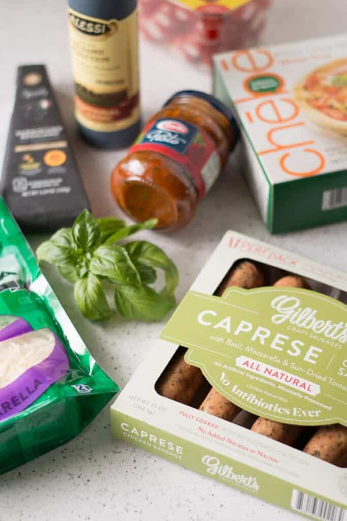 Ingredients for Caprese Chicken Pizza laid out on table.  