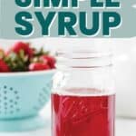 Bright red strawberry simple syrup in mason jar.