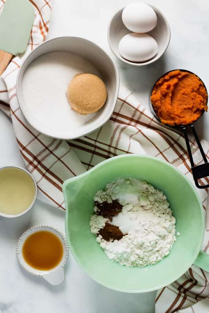 Ingredients for Gluten-free Pumpkin Bars on a plaid table runner.