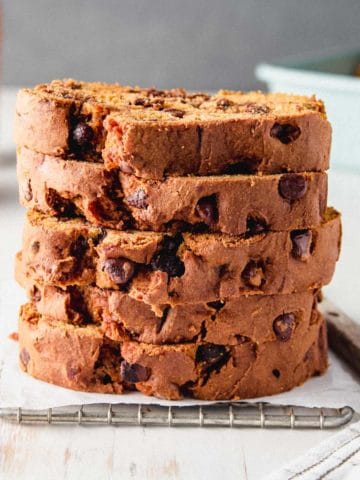 A stack of slices of gluten-free pumpkin bread studded with chocolate chips.