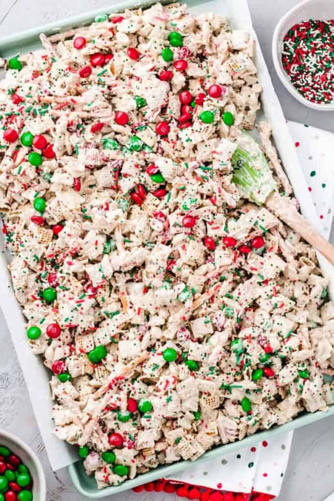 Christmas Crunch Mix on green cookie sheet with parchment paper.