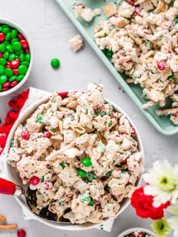 Christmas Chex min in a bowl and on mint green cookie sheet.