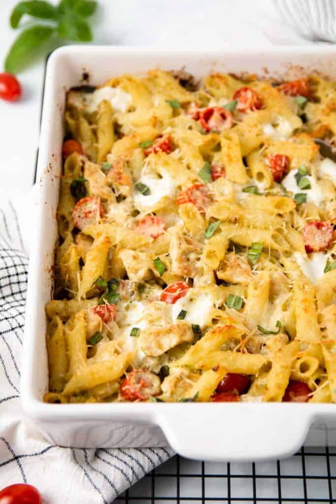 Baked Chicken Pesto Pasta in casserole dish with a sprinkle of fresh basil on top.
