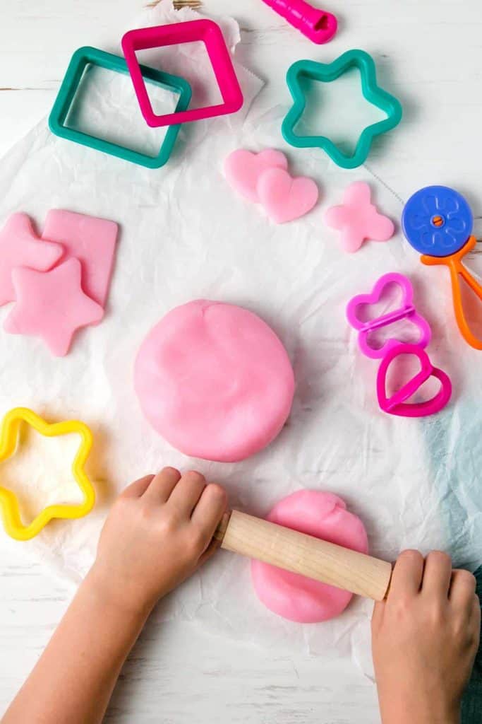 Pink gluten-free playdough along with play-dough accessories.