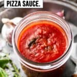 Pizza sauce in a mason jar on old pie dish.