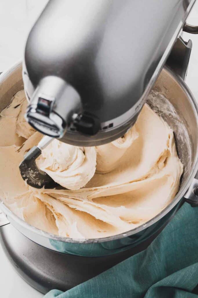 The dough mixing in a silver kitchenmaid stand mixer.