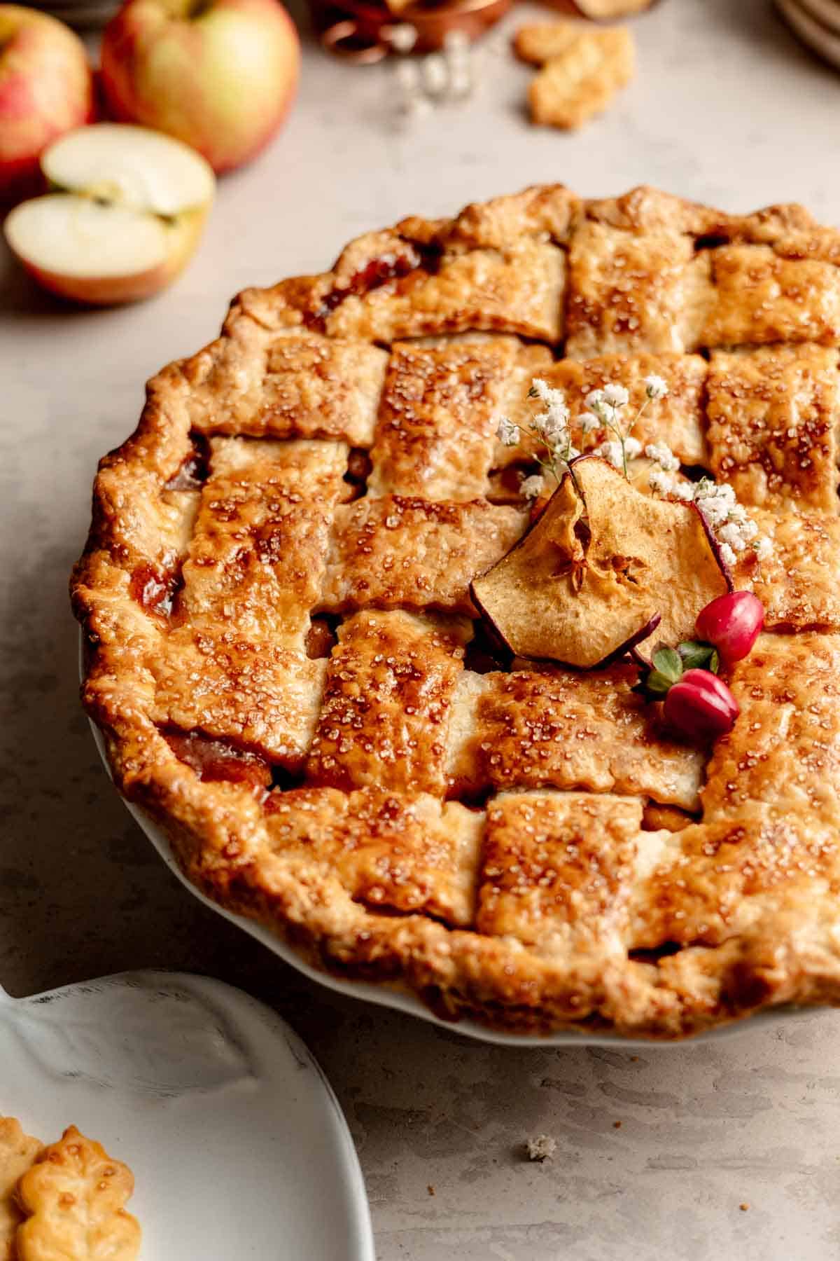 A lattice topped gluten free apple pie garnished with apple chips and baby's breath.