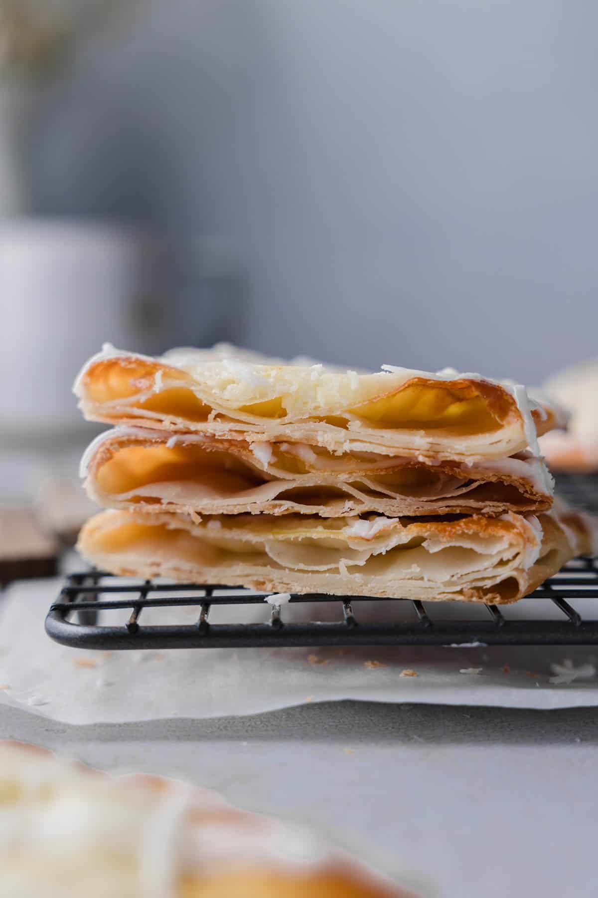 A stack of cheese danish cut open to show flaky layers. 