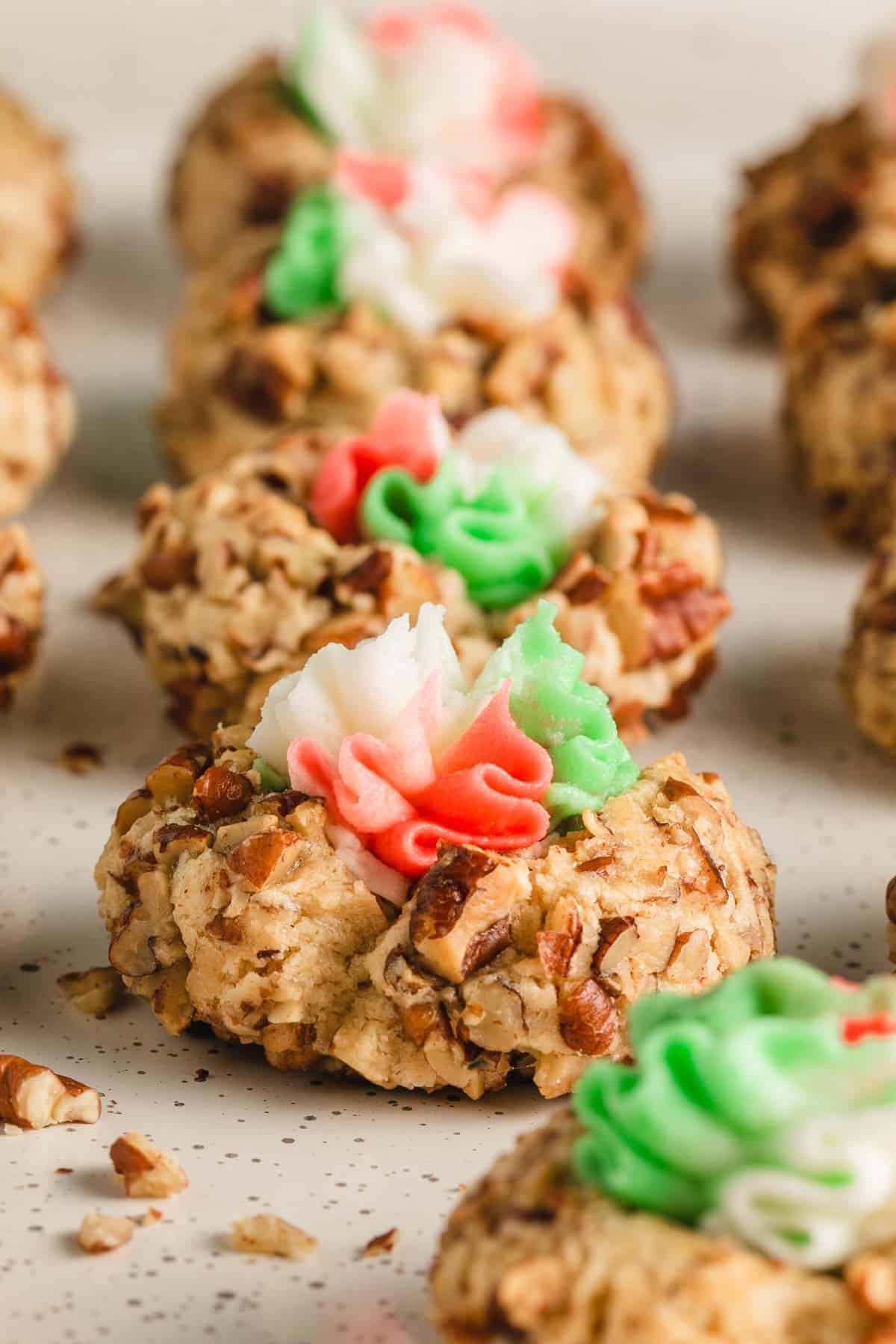 A row of thumbprints with red, white, and green buttercream icing.