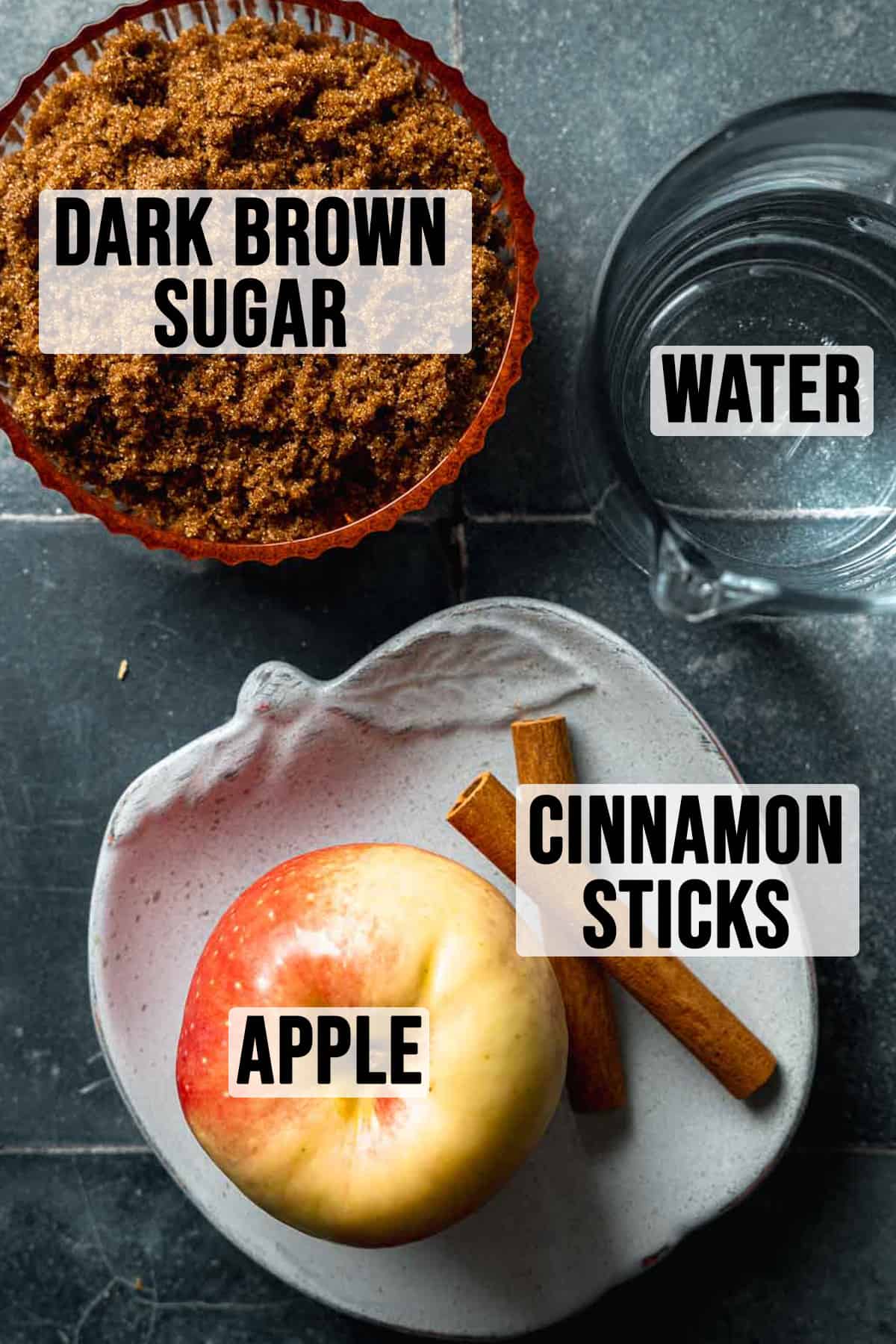 Ingredients for apple brown sugar syrup measured out in bowls on dark blue tile surface.