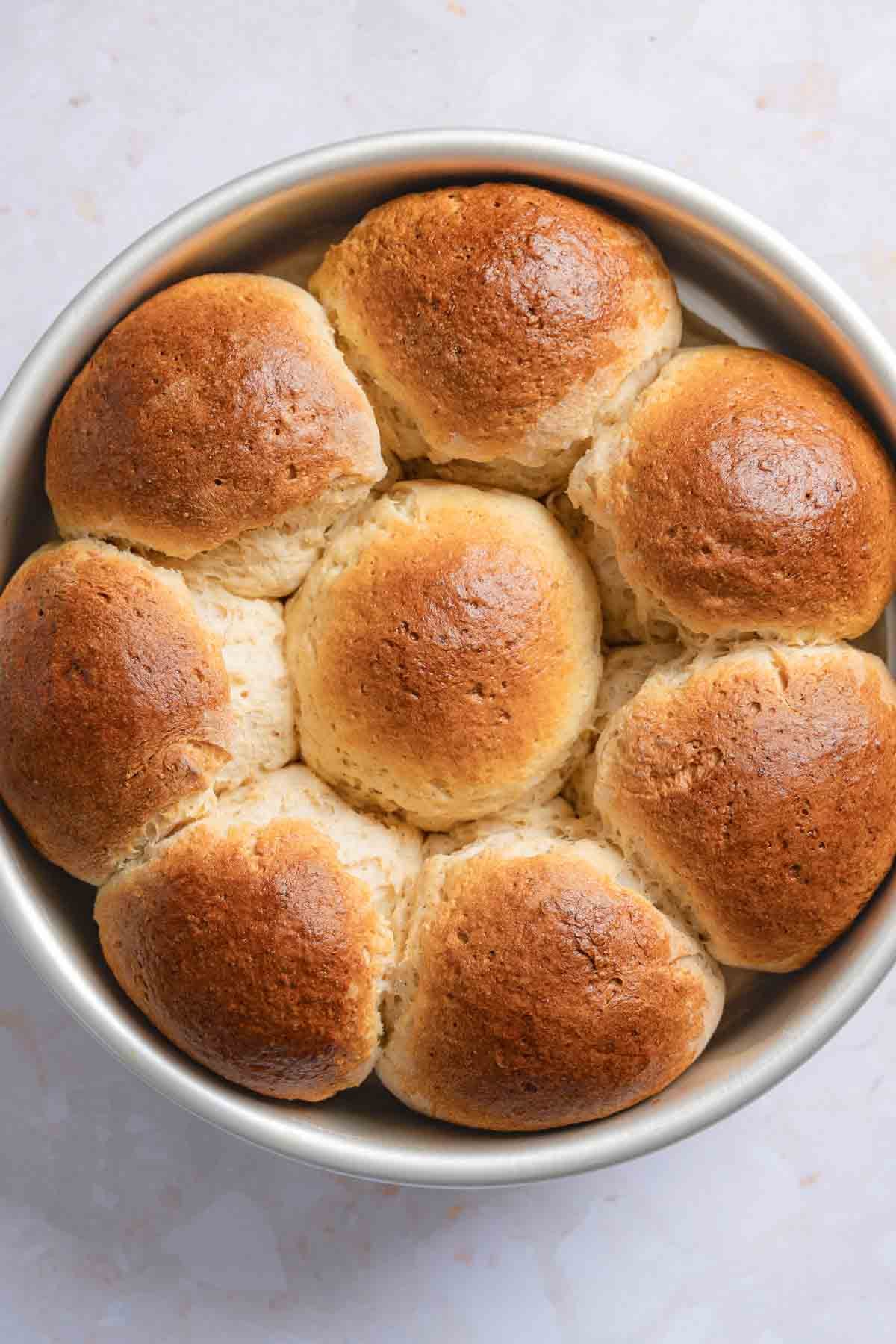 Golden brown Hawaiian rolls in pan, after baking.