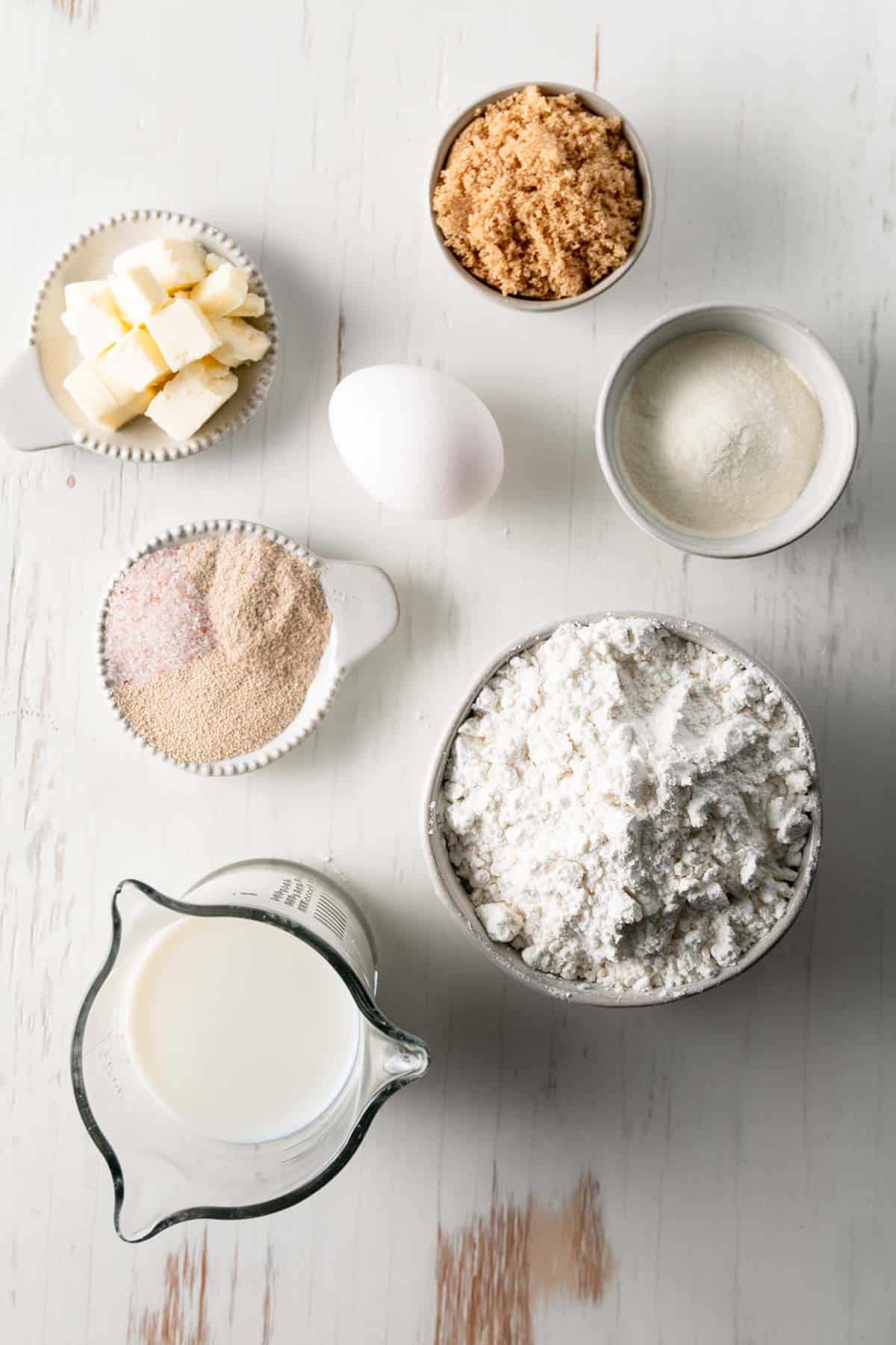 Ingredients for the rolls measured out in bowls and measuring cups. The butter is cubed.