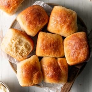 A plate of gluten free Hawaiian rolls, one on it's side to show texture.