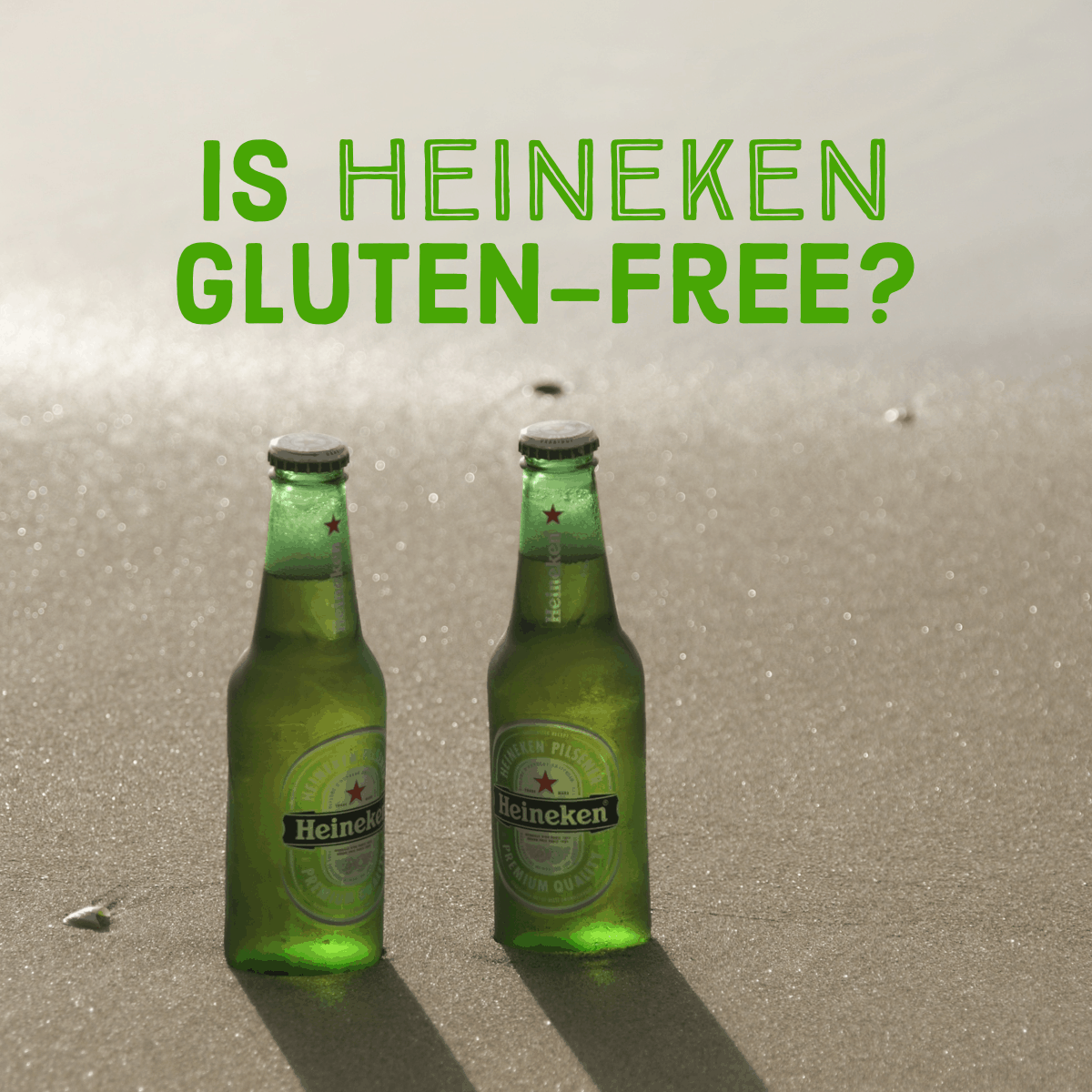 Two heineken bottles in the sand.