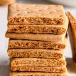 A stack of gluten-free graham crackers, with on leaning on the stack.