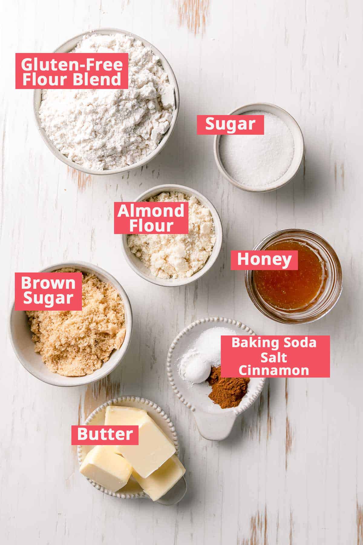 Ingredients for the recipe measured out in bowls including honey, almond flour, sugars, and butter.