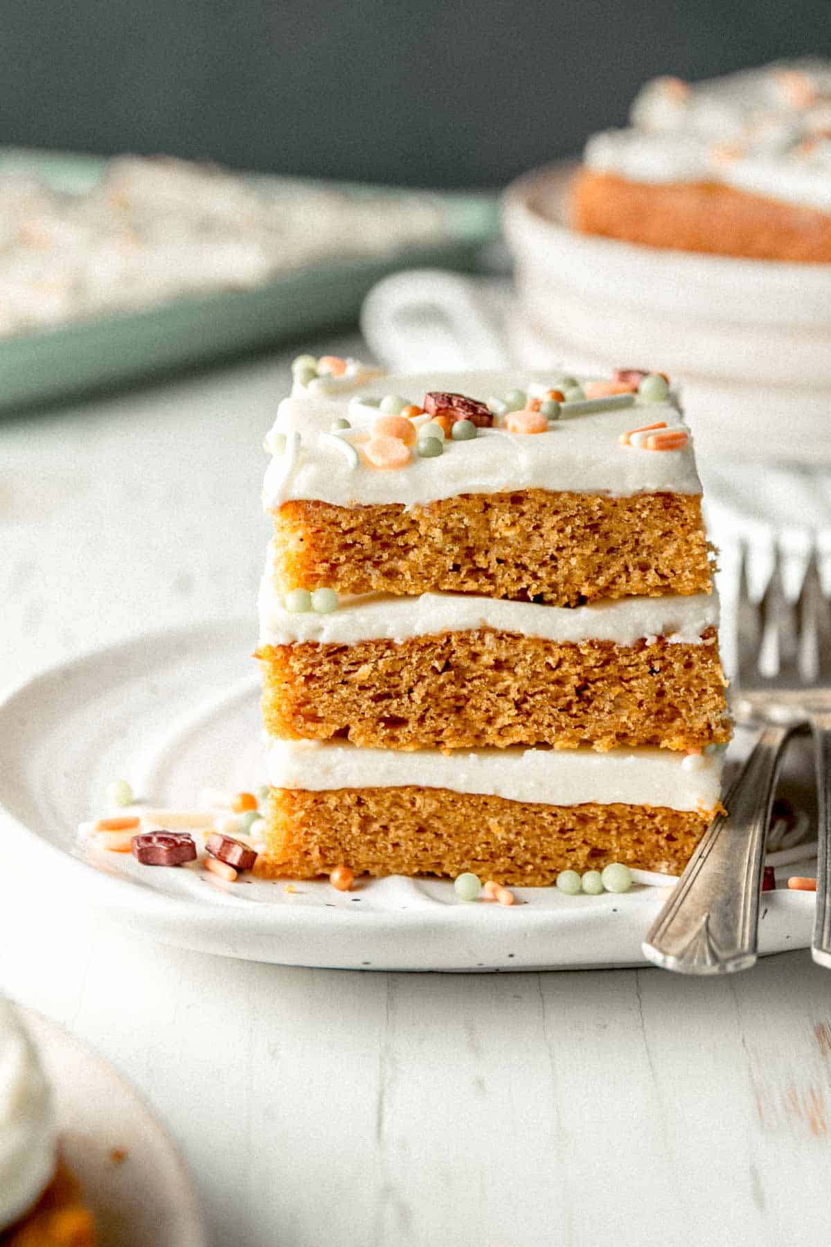 A stack of three gluten-free pumpkin bars topped with sprinkles on a small pumpkin plate.