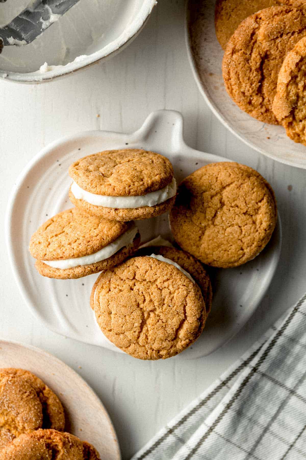 Gluten-free pumpkin sandwich cookies on a small pumpkin shaped plate.