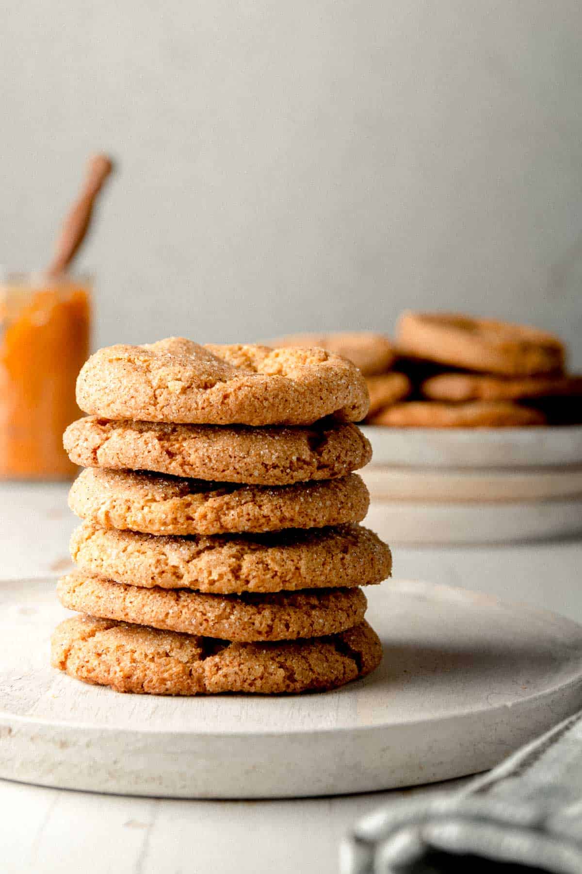 A stack of gluten-free pumpkin cookies on a white wooden plate.