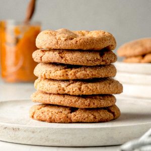 A stack of gluten-free pumpkin cookies on a wooden plate.