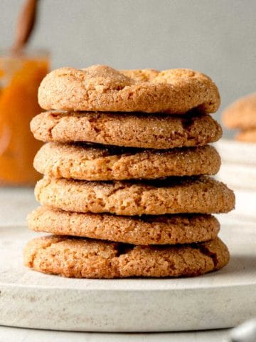 A stack of gluten-free pumpkin cookies on a wooden plate.