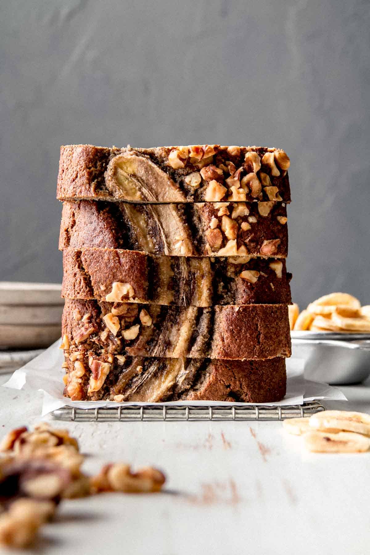 A stack of buckwheat banana bread slices on parchment paper.