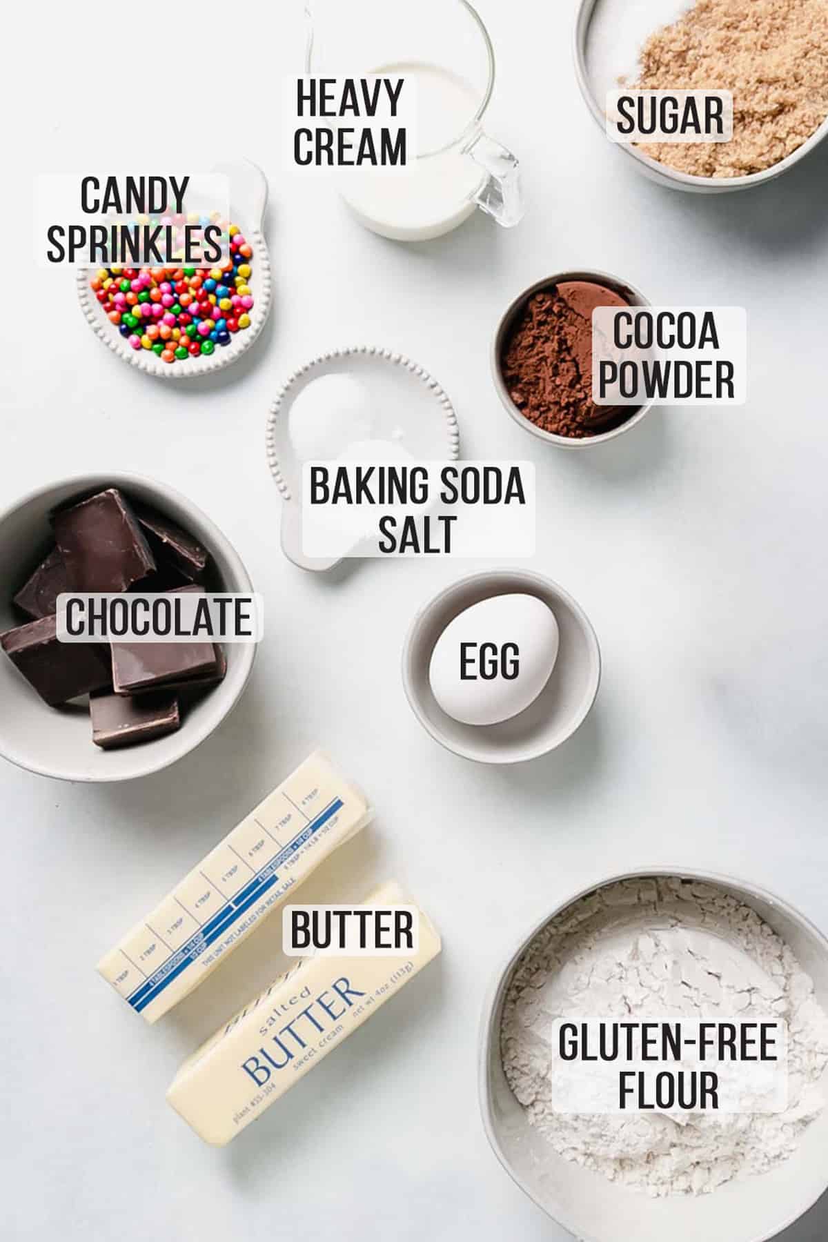 Ingredients for the recipe measured out in bowls on white surface.