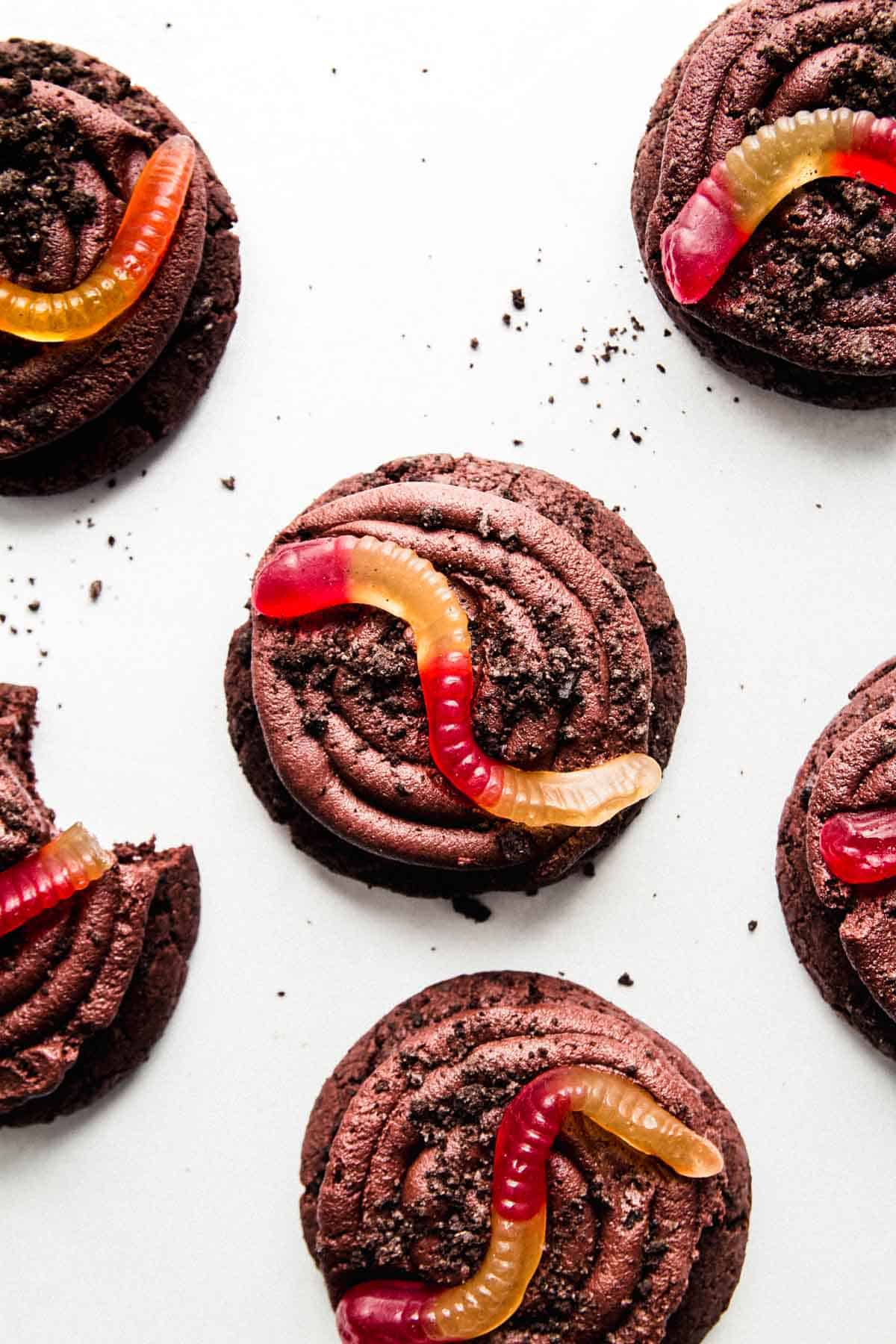 Gluten-free Oreo dirt cookies topped with a swirl of chocolate frosting, Oreo crumbles, and a gummy worm.