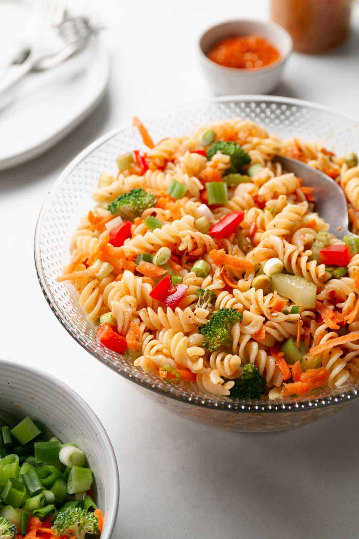 Gluten-free Italian Pasta Salad filled with chopped veggies in a glass bowl.