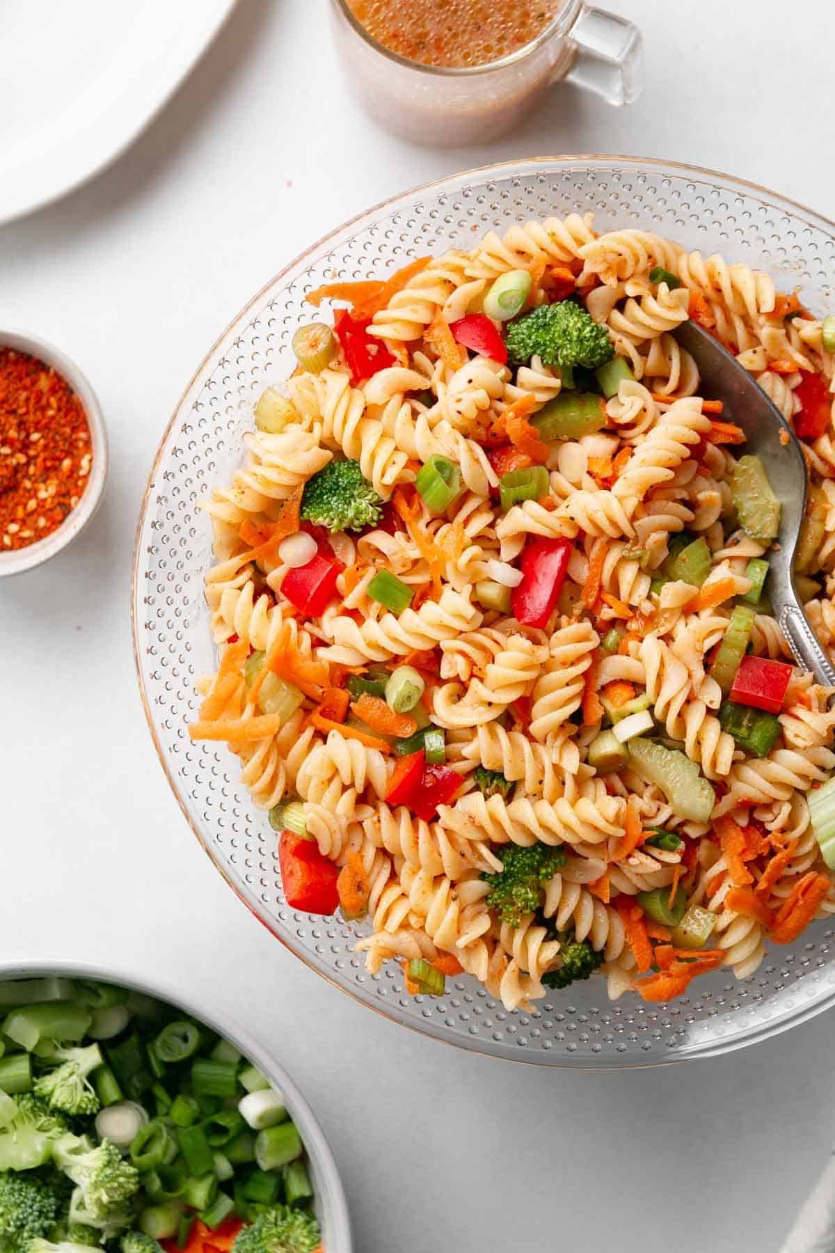 A big bowl full of gluten free pasta and veggies tossed in Italian dressing.