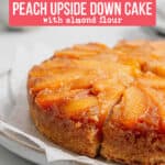 Side view of baked gluten-free peach cake with golden brown edges and gooey peaches on top.