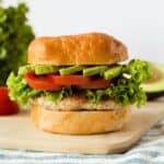 Ground chicken burger on a bun with lettuce tomato and avocado.