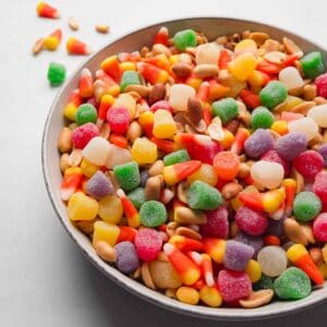 A bowl full of candy corn trail mix: candy corn, peanuts, and spice drops.