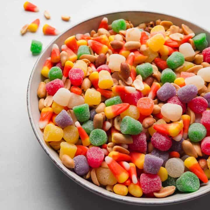 A bowl full of candy corn trail mix: candy corn, peanuts, and spice drops.