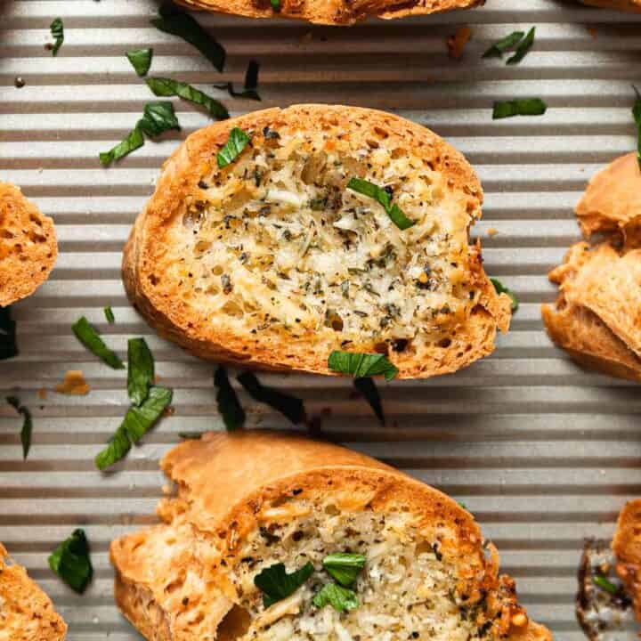 Golden brown gluten free garlic bread on a baking sheet.