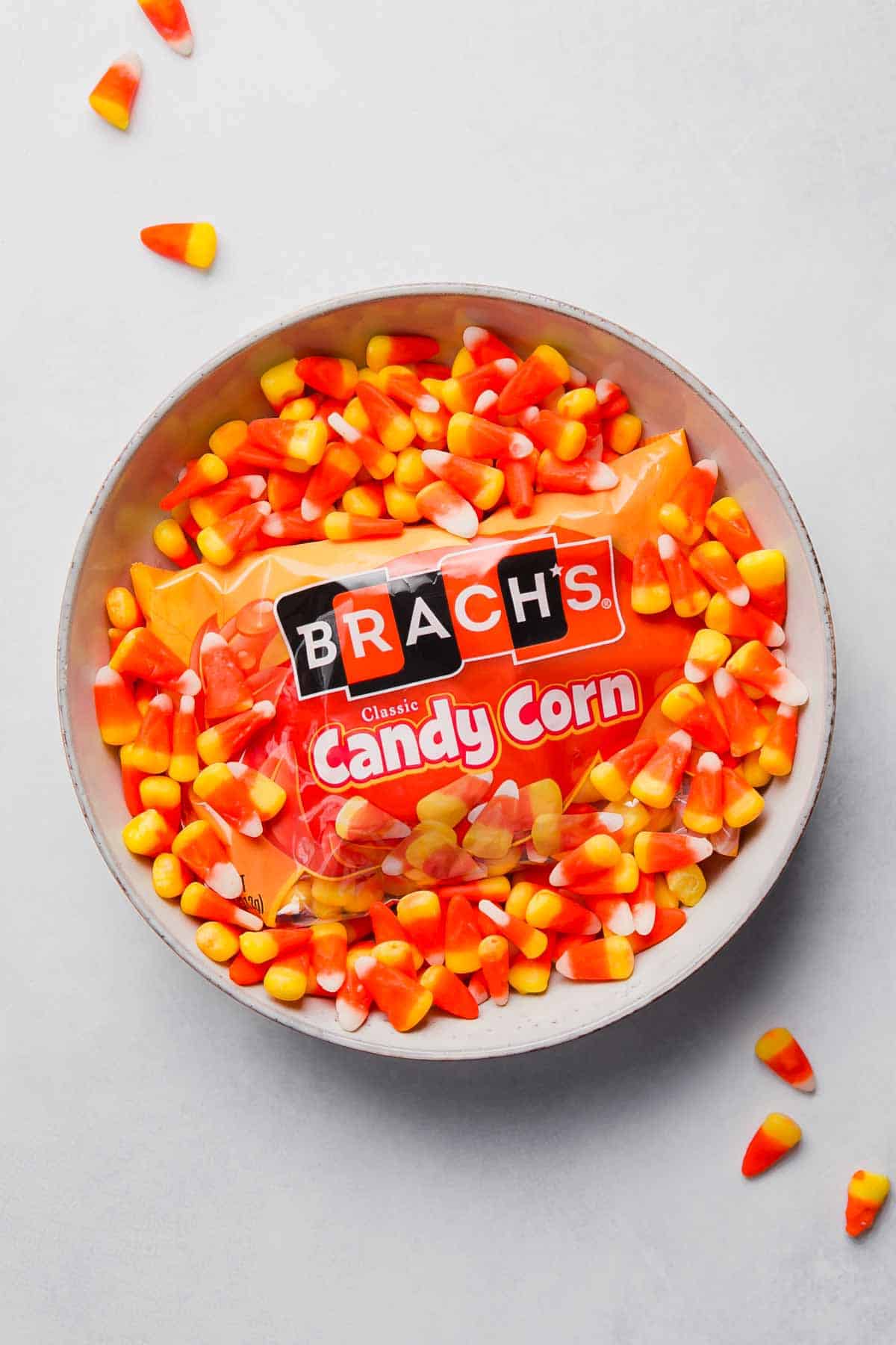 Brach's candy corn in a bowl with a package in the center.