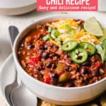 Gluten-Free Chili in a bowl with cheese and green onions next to tortilla chips.