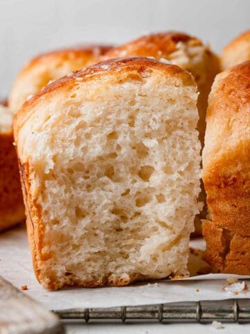 Fluffy gluten-free dinner roll is golden brown and airy.
