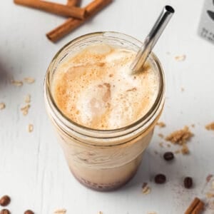 Brown sugar shaken espresso with foamy top and ice in mason jar with metal straw.