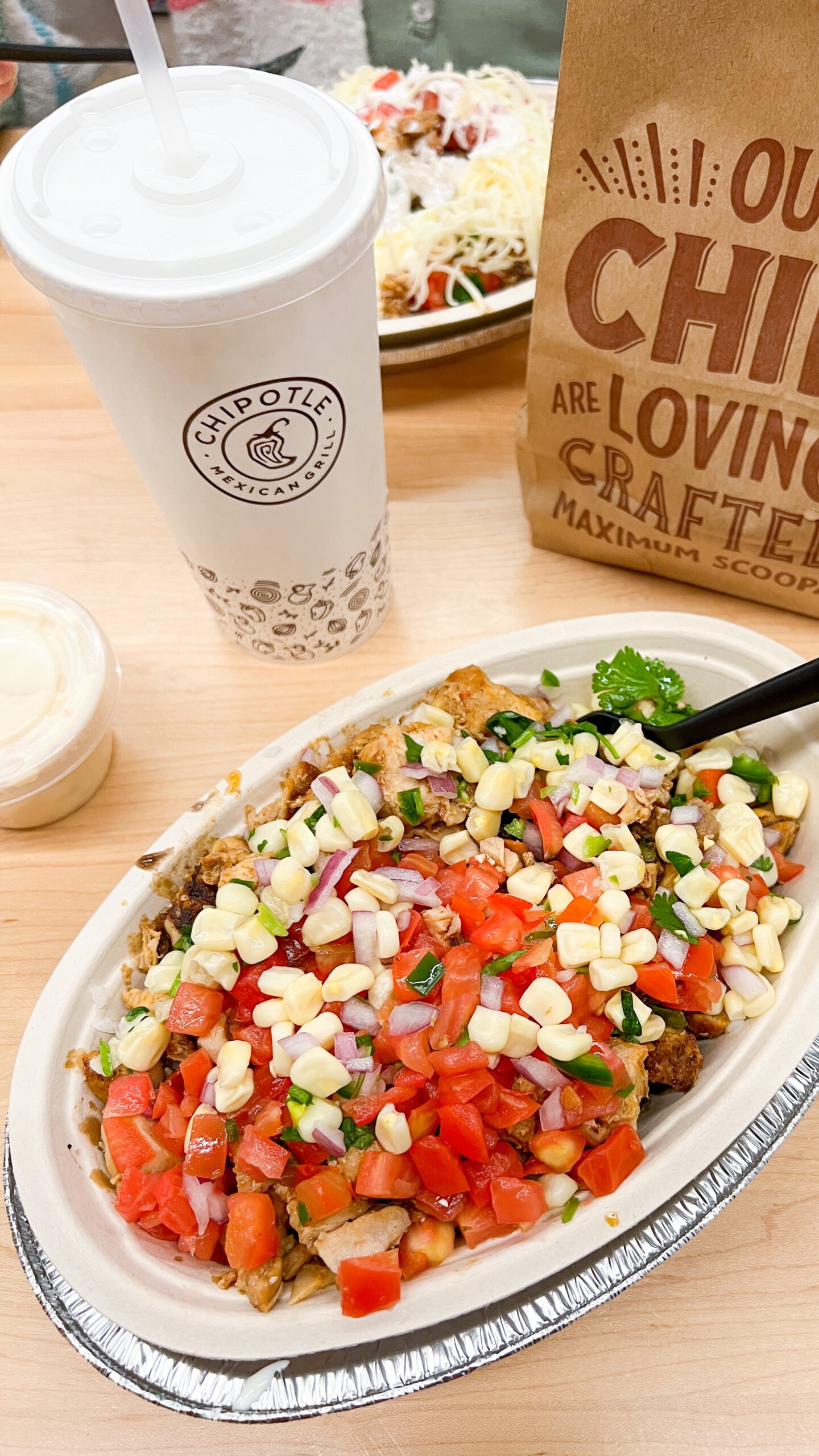 Chipotle chicken burrito bowl with fresh tomato salsa and corn salsa on top.